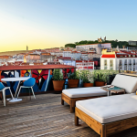 Lisbon Street Art Terrace View**

"A vibrant rooftop terrace overlooking Lisbon's Bairro Alto district. In the foreground, a stylish outdoor lounge area with comfortable seating and modern decor reminiscent of The Independente Hostel & Suites. In the background, a panorama of colorful street art murals covering buildings, capturing the essence of Lisbon's urban art scene. Golden hour lighting, high detail, realistic, safe for work, appropriate content, fully clothed, professional."

**